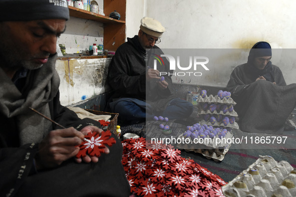 In Srinagar, Kashmir, India, on December 14, 2024, Kashmiri artisan Muhammad Akhtar Mir paints Christmas gift items at his workshop before s...