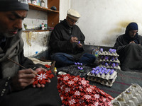 In Srinagar, Kashmir, India, on December 14, 2024, Kashmiri artisan Muhammad Akhtar Mir paints Christmas gift items at his workshop before s...