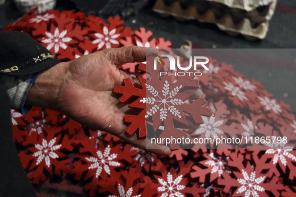 In Srinagar, Kashmir, India, on December 14, 2024, a Kashmiri artisan shows gift items at the workshop before sending them to the market ahe...