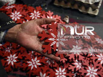 In Srinagar, Kashmir, India, on December 14, 2024, a Kashmiri artisan shows gift items at the workshop before sending them to the market ahe...