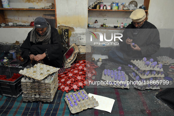 In Srinagar, Kashmir, India, on December 14, 2024, Kashmiri artisan Muhammad Akhtar Mir paints Christmas gift items at his workshop before s...