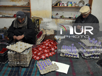 In Srinagar, Kashmir, India, on December 14, 2024, Kashmiri artisan Muhammad Akhtar Mir paints Christmas gift items at his workshop before s...