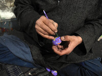 In Srinagar, Kashmir, India, on December 14, 2024, Kashmiri artisan Muhammad Akhtar Mir paints Christmas gift items at his workshop ahead of...