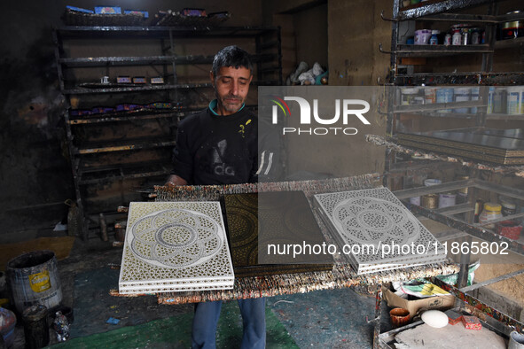 In Srinagar, Kashmir, India, on December 14, 2024, a Kashmiri artisan shows gift items at the workshop before sending them to the market ahe...