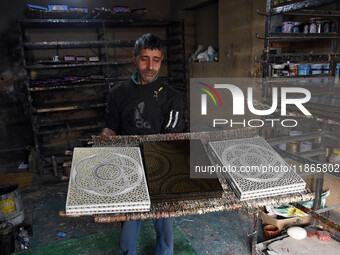 In Srinagar, Kashmir, India, on December 14, 2024, a Kashmiri artisan shows gift items at the workshop before sending them to the market ahe...