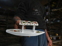 In Srinagar, Kashmir, India, on December 14, 2024, a Kashmiri artisan displays a Christmas ornament at the workshop before sending it to the...