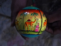 In Srinagar, Kashmir, India, on December 14, 2024, a Kashmiri artisan shows a Christmas bauble at the workshop before sending it to the mark...