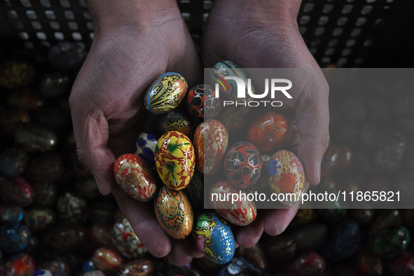 In Srinagar, Kashmir, India, on December 14, 2024, a Kashmiri artisan shows baubles at the workshop before sending them to the market ahead...