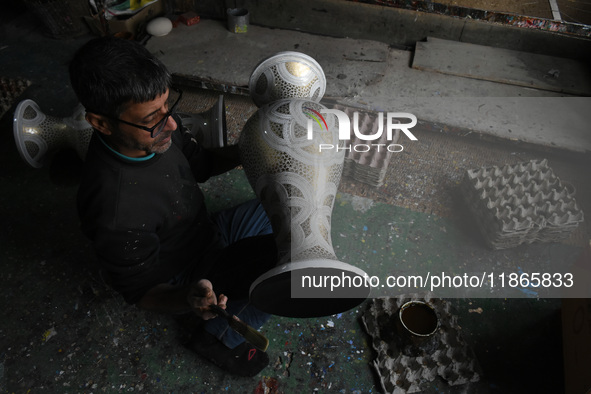 In Srinagar, Kashmir, India, on December 14, 2024, a Kashmiri artisan paints Christmas gift items at the workshop before sending them to the...