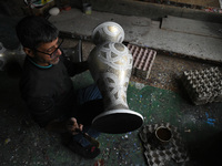 In Srinagar, Kashmir, India, on December 14, 2024, a Kashmiri artisan paints Christmas gift items at the workshop before sending them to the...