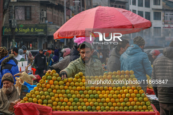 A street vendor sells oranges at a market in Srinagar, Jammu and Kashmir, on December 14, 2024. 