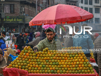 A street vendor sells oranges at a market in Srinagar, Jammu and Kashmir, on December 14, 2024. (