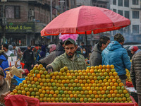 A street vendor sells oranges at a market in Srinagar, Jammu and Kashmir, on December 14, 2024. (