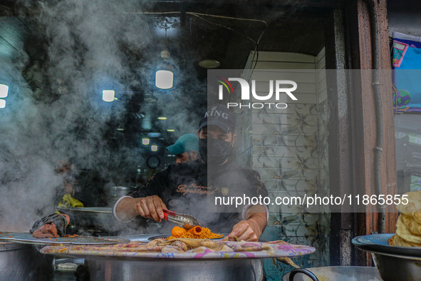 A man prepares Biryani, a traditional mixed rice dish, at a market in Srinagar, Jammu and Kashmir, on December 14, 2024. 