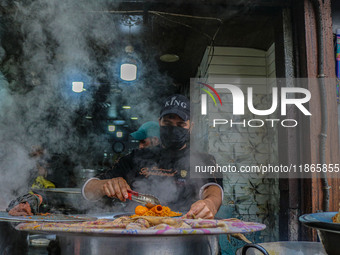 A man prepares Biryani, a traditional mixed rice dish, at a market in Srinagar, Jammu and Kashmir, on December 14, 2024. (