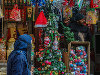 A woman walks past Santa Claus items in a shop at a market ahead of the Christmas celebrations in Srinagar, Jammu and Kashmir, on December 1...