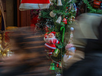 People walk past a Santa Claus decorative article displayed at a market ahead of the Christmas celebrations in Srinagar, Jammu and Kashmir,...