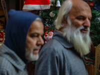 People walk past a Santa Claus decorative article displayed at a market ahead of the Christmas celebrations in Srinagar, Jammu and Kashmir,...