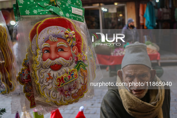 An elderly man looks on as Santa Claus items are seen in a shop at a market ahead of the Christmas celebrations in Srinagar, Jammu and Kashm...