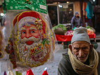 An elderly man looks on as Santa Claus items are seen in a shop at a market ahead of the Christmas celebrations in Srinagar, Jammu and Kashm...