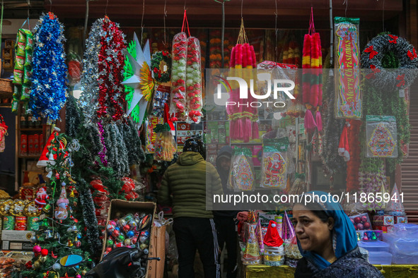 A woman walks past Santa Claus items in a shop at a market ahead of the Christmas celebrations in Srinagar, Jammu and Kashmir, on December 1...