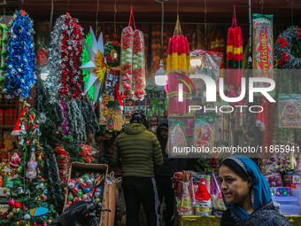 A woman walks past Santa Claus items in a shop at a market ahead of the Christmas celebrations in Srinagar, Jammu and Kashmir, on December 1...