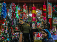 A woman walks past Santa Claus items in a shop at a market ahead of the Christmas celebrations in Srinagar, Jammu and Kashmir, on December 1...