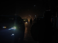 A man walks during a cold winter evening in Sopore, Jammu and Kashmir, India, on December 14, 2024. (