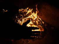 A man warms his hands by a fire during a cold winter evening in Sopore, Jammu and Kashmir, India, on December 14, 2024. (