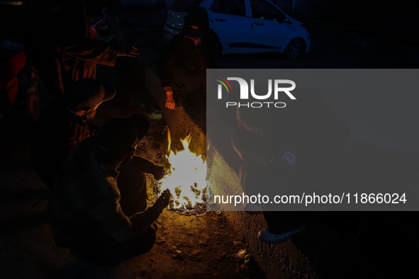 Kashmiri boys warm their hands on a bonfire in Sopore, Jammu and Kashmir, India, on December 14, 2024. 