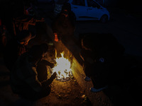 Kashmiri boys warm their hands on a bonfire in Sopore, Jammu and Kashmir, India, on December 14, 2024. (