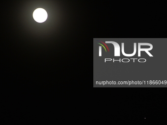 The planet Venus appears as the Moon is visible in the night sky in Siliguri, India, on December 14, 2024. (