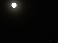 The planet Venus appears as the Moon is visible in the night sky in Siliguri, India, on December 14, 2024. (