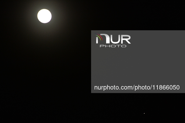 The planet Venus appears as the Moon is visible in the night sky in Siliguri, India, on December 14, 2024. 