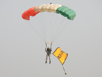 An Indian army paratrooper jumps from a plane carrying a flag during the full dress rehearsal ahead of ''Vijay Diwas,'' a ceremony to celebr...