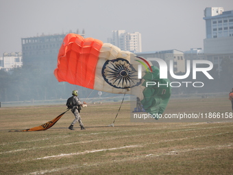 An Indian army paratrooper jumps from a plane carrying an Indian national flag during the full dress rehearsal ahead of ''Vijay Diwas,'' a c...