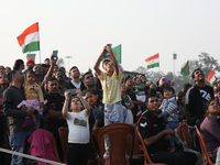 People watch Indian Army personnel with helicopters perform a drill during the full dress rehearsal ahead of ''Vijay Diwas'', a ceremony to...