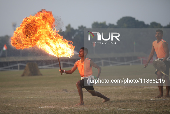 An Indian army soldier blows fire from his mouth as he performs during the full dress rehearsal ahead of ''Vijay Diwas'', a ceremony to cele...