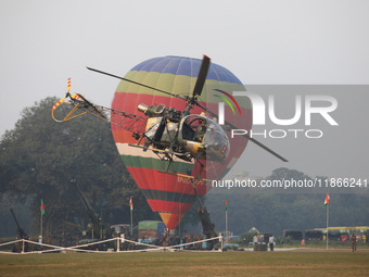 An Indian Army personnel and a helicopter fly past a hot air balloon during the full dress rehearsal ahead of ''Vijay Diwas,'' a ceremony to...