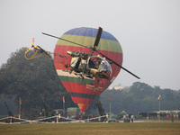 An Indian Army personnel and a helicopter fly past a hot air balloon during the full dress rehearsal ahead of ''Vijay Diwas,'' a ceremony to...