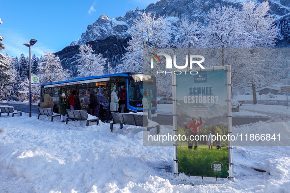 Passengers wait for the bus to Grainau amidst the snowy landscape at Lake Eibsee in Bavaria, Germany, on December 13, 2024. A group of peopl...