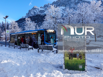 Passengers wait for the bus to Grainau amidst the snowy landscape at Lake Eibsee in Bavaria, Germany, on December 13, 2024. A group of peopl...