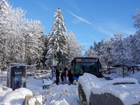 Passengers wait for the bus to Grainau amidst the snowy landscape at Lake Eibsee in Bavaria, Germany, on December 13, 2024. A group of peopl...