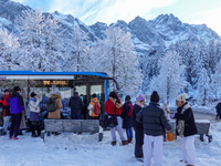 Passengers wait for the bus to Grainau amidst the snowy landscape at Lake Eibsee in Bavaria, Germany, on December 13, 2024. A group of peopl...