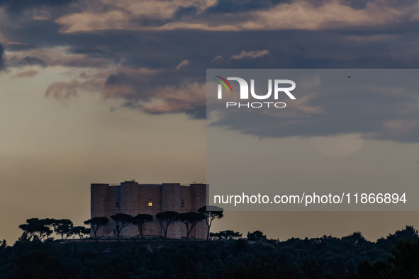 The December full moon, also known as the Cold Moon, appears in the clouds near Castel del Monte in Andria, Apulia, on December 14, 2024. 