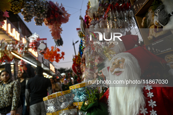 People walk past a stall with decorative articles ahead of the Christmas celebrations in New Delhi, India, on December 14, 2024. 