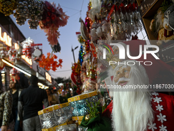 People walk past a stall with decorative articles ahead of the Christmas celebrations in New Delhi, India, on December 14, 2024. (