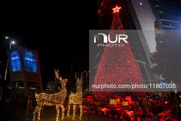 A Christmas tree with decorative lights is visible on a road in Gurugram, India, on December 14, 2024. 