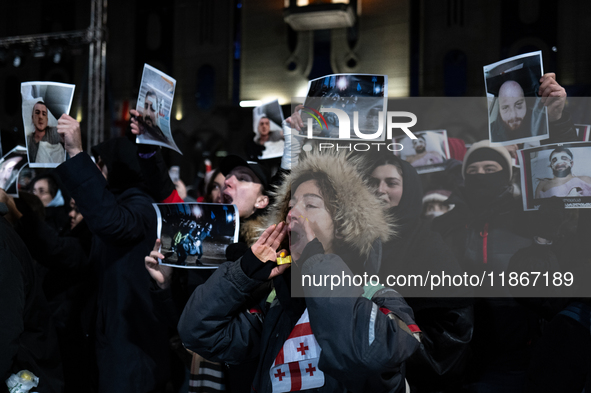 Anti-government demonstrators gather outside the Georgian parliament after the parliament members elect a new president in Tbilisi, Georgia,...