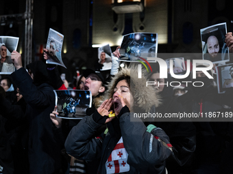 Anti-government demonstrators gather outside the Georgian parliament after the parliament members elect a new president in Tbilisi, Georgia,...